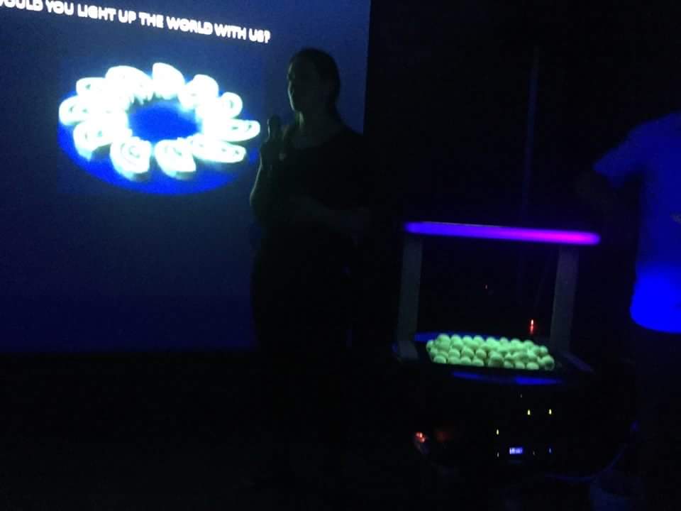 Me presenting glowing Luma Bites food at a UV-lit event