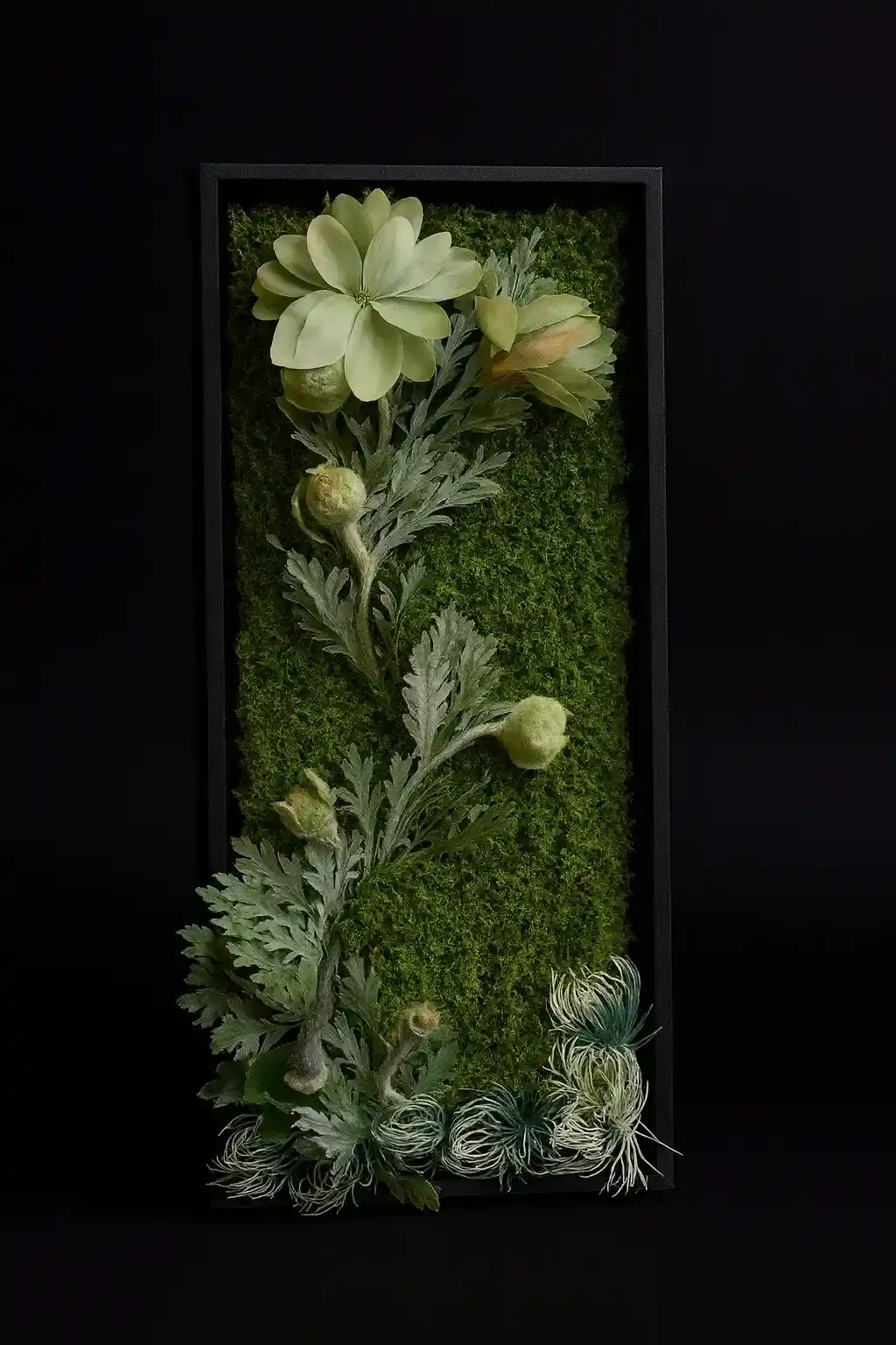 A tall dark frame filled with layered greenery and botanical textures
